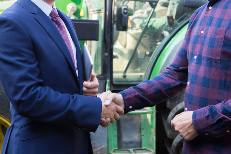 business man shakes hand with farmer